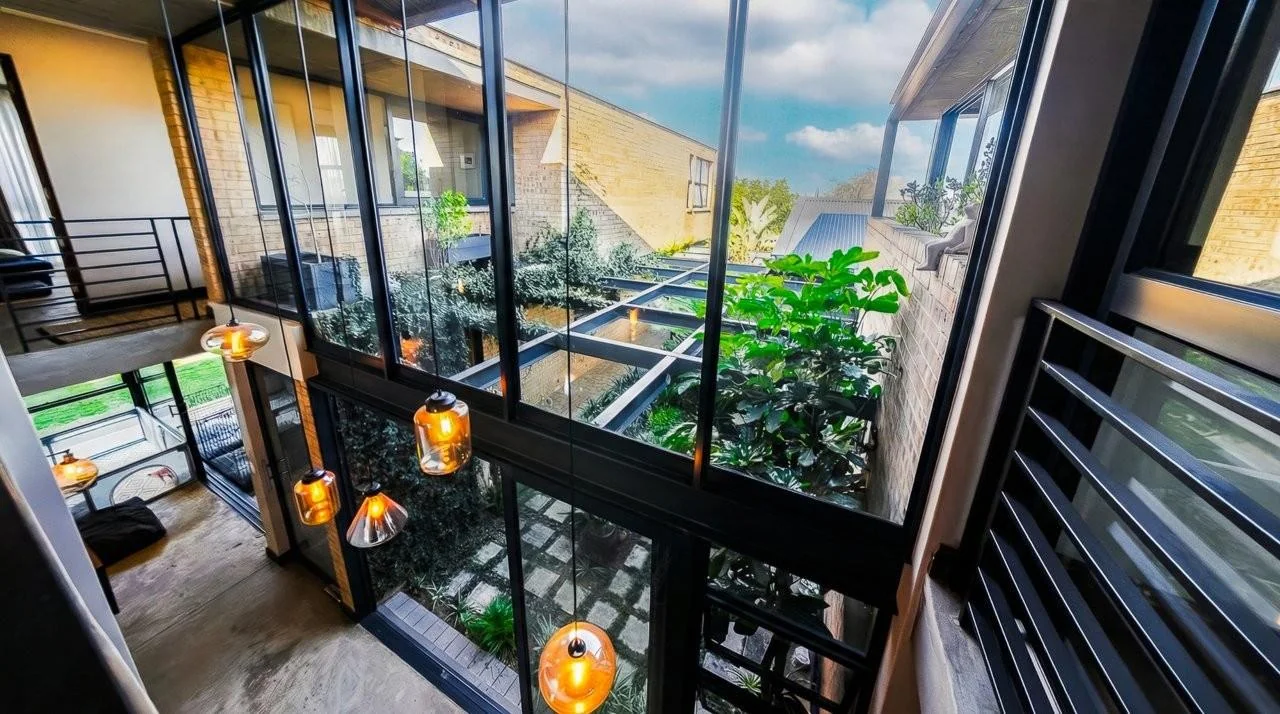 A STRIKING INDUSTRIAL-MODERN HOME IN  A PRIME MIDSTREAM RIDGE LOCATION, MOMENTS FROM AN  ACCESS GATE