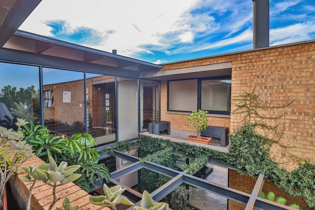 A STRIKING INDUSTRIAL-MODERN HOME IN  A PRIME MIDSTREAM RIDGE LOCATION, MOMENTS FROM AN  ACCESS GATE