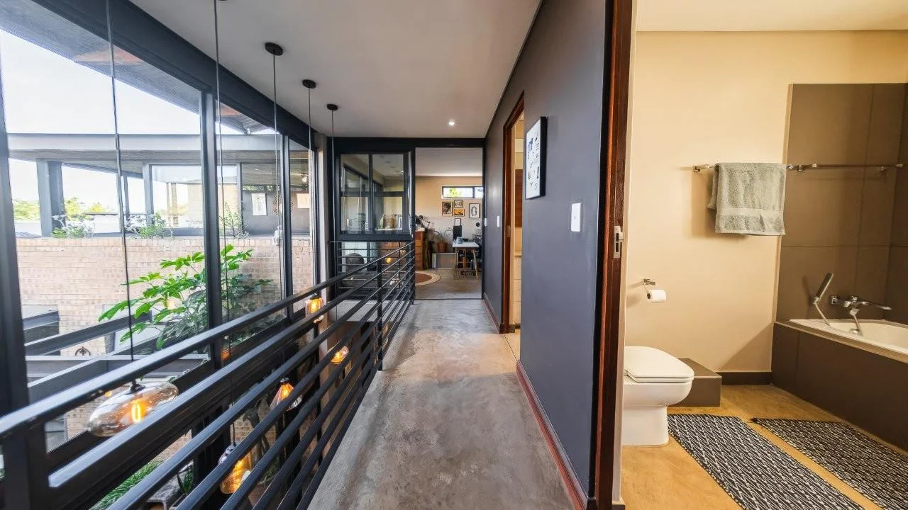 A STRIKING INDUSTRIAL-MODERN HOME IN  A PRIME MIDSTREAM RIDGE LOCATION, MOMENTS FROM AN  ACCESS GATE