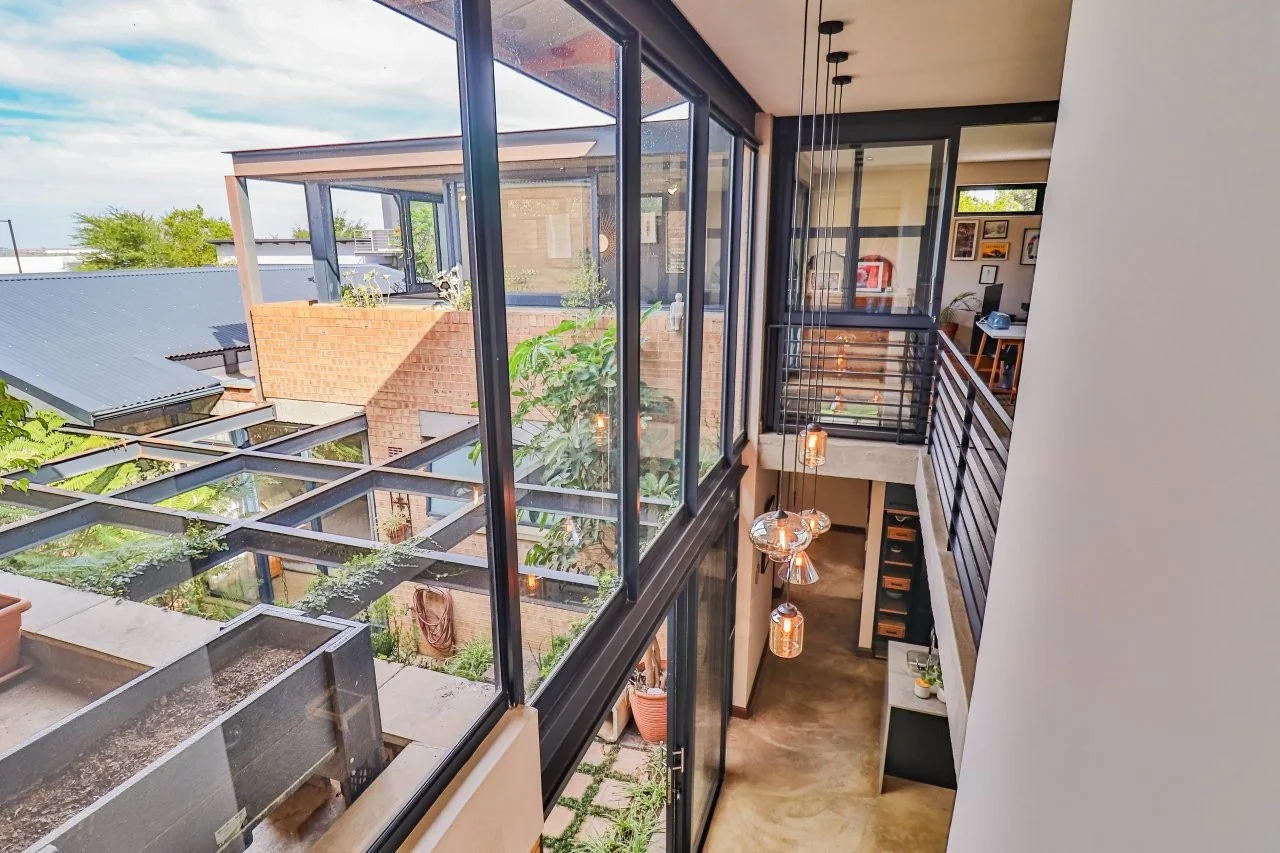 A STRIKING INDUSTRIAL-MODERN HOME IN  A PRIME MIDSTREAM RIDGE LOCATION, MOMENTS FROM AN  ACCESS GATE