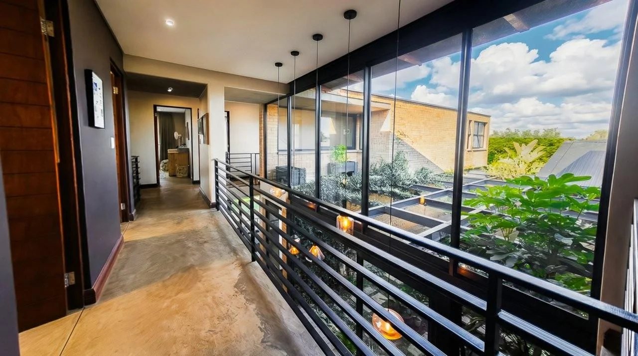 A STRIKING INDUSTRIAL-MODERN HOME IN  A PRIME MIDSTREAM RIDGE LOCATION, MOMENTS FROM AN  ACCESS GATE