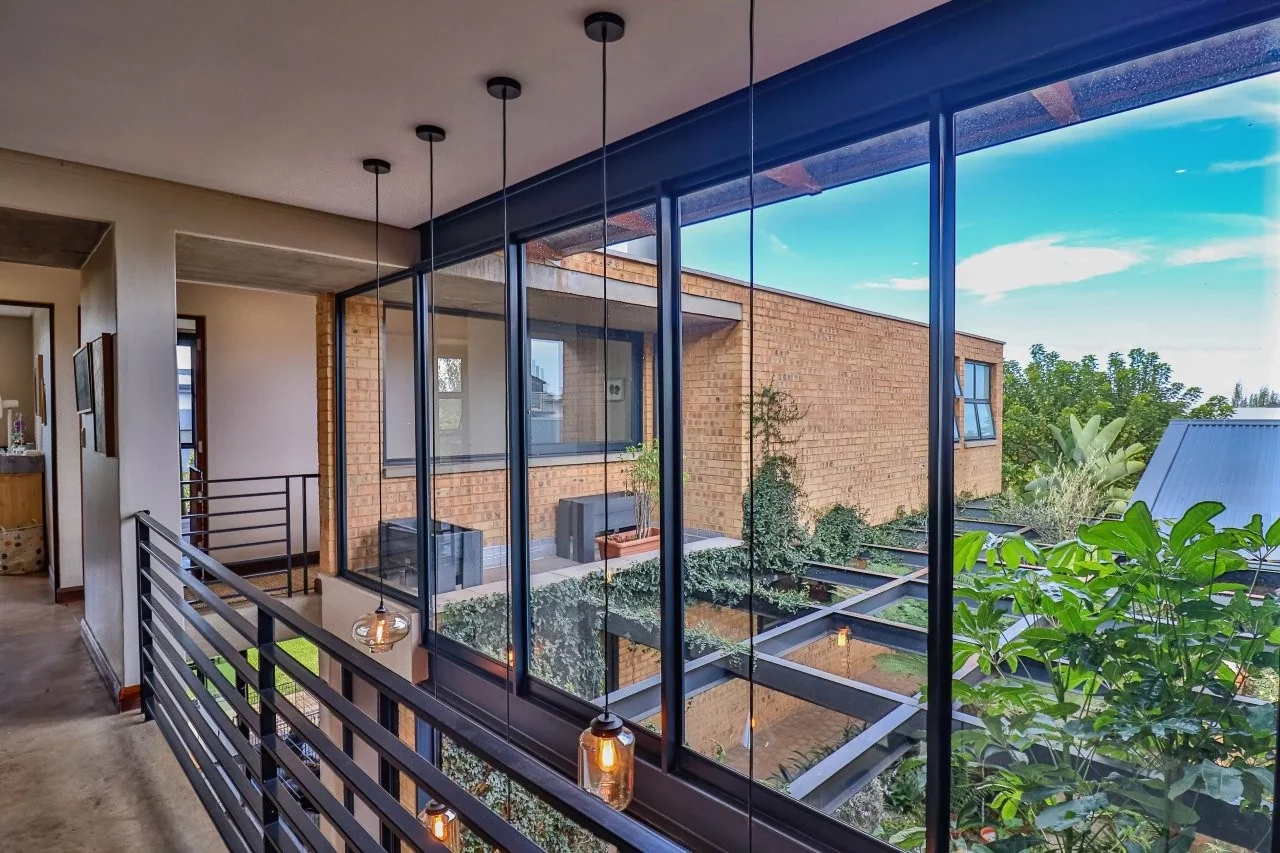 A STRIKING INDUSTRIAL-MODERN HOME IN  A PRIME MIDSTREAM RIDGE LOCATION, MOMENTS FROM AN  ACCESS GATE